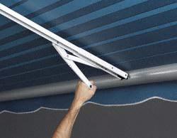 How is this awning support attached to the coach when not in use? Does it support the awning rail when rolled up?